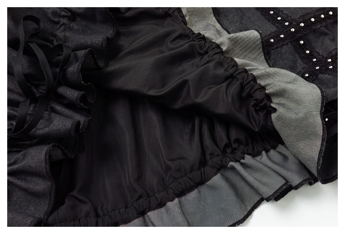 Inside view of a black garment with smooth lining, gathered seams, gray ruffled panels, and studded trim.