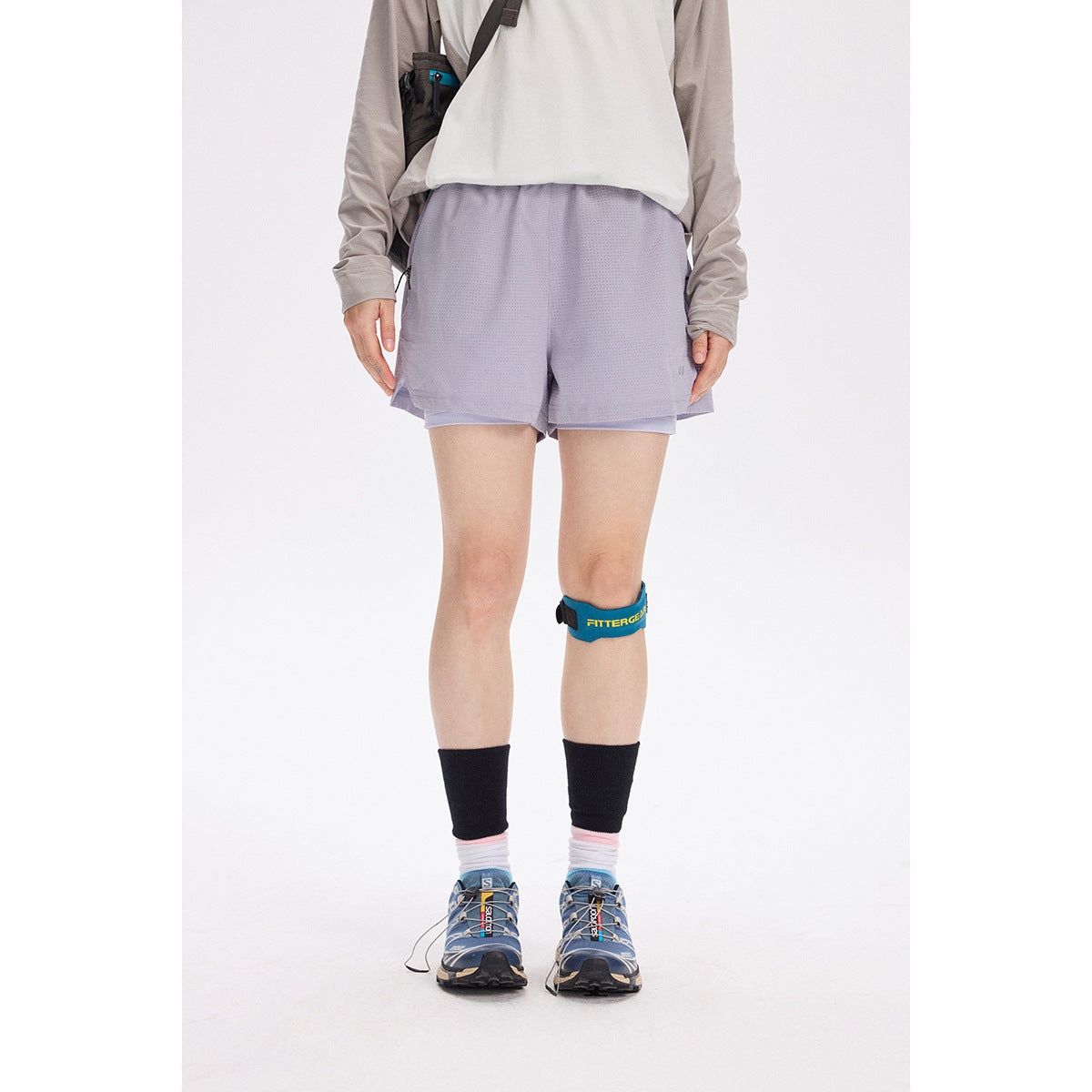 Front view of a model wearing pale lavender running shorts with a mesh-like texture and layered liners.