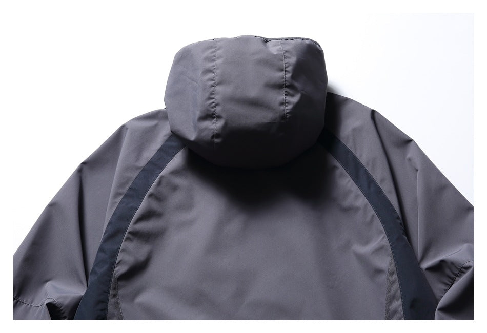 Close-up of a charcoal gray jacket's back, showing the hood and dark curved shoulder panels.