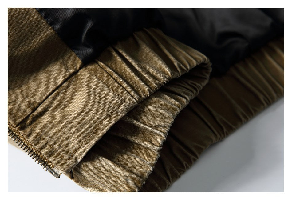 Close-up of the gathered tan-brown jacket hem beside the black lining and zipper end.