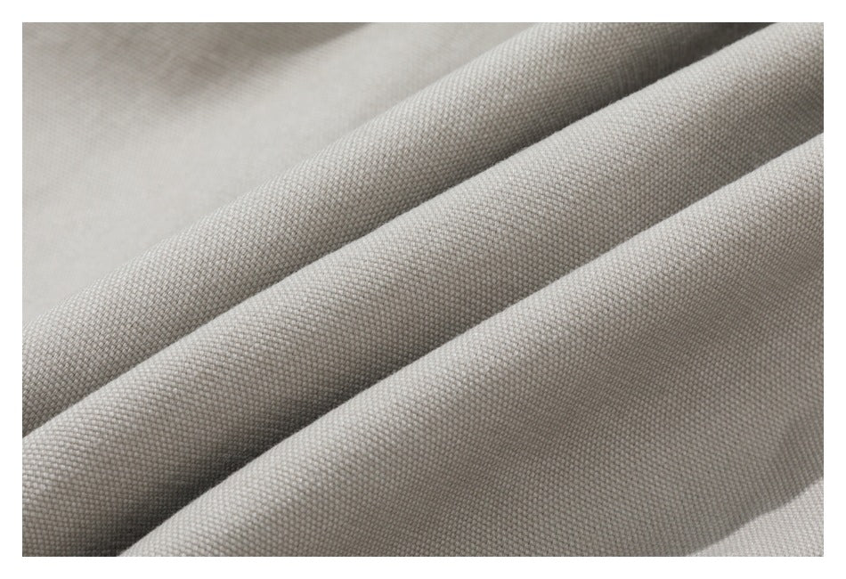 Macro view of beige woven garment fabric arranged in soft folds.
