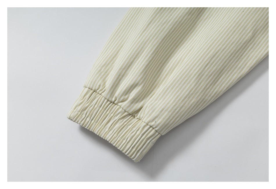 Close-up of a cream and pale yellow striped sleeve ending in a gathered elastic cuff.