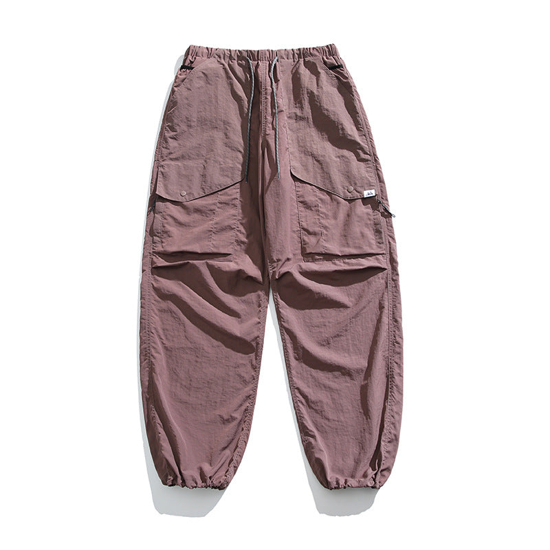 Dusty purple cargo pants flat lay with drawstring waist, large snap flap pockets and drawstring hems