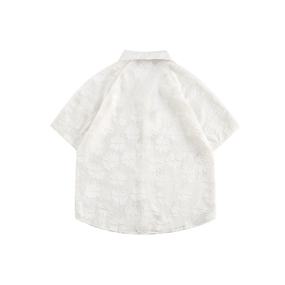 Back view of a white short-sleeve collared shirt with a raised floral pattern.