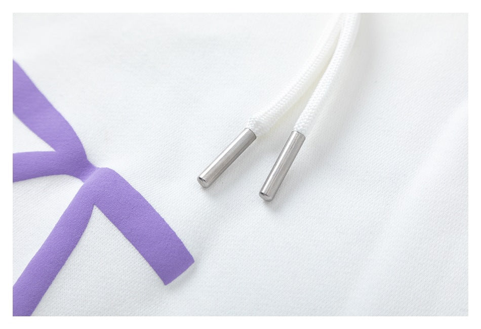Close-up of the white hoodie drawstrings with silver-colored metal tips beside part of a purple graphic.
