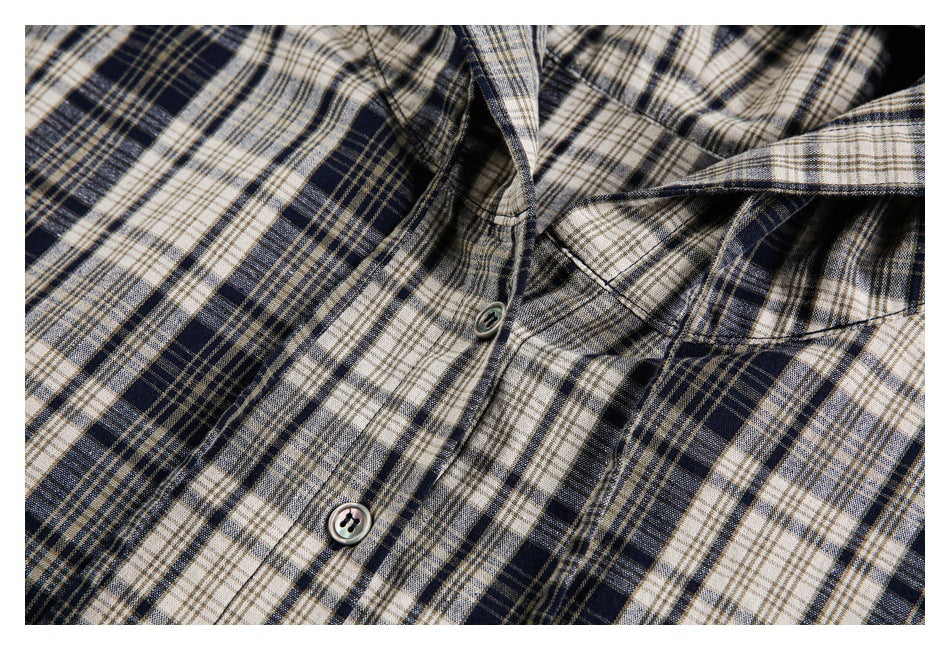 Close-up of the plaid jacket's front placket, buttons, and hood seam.