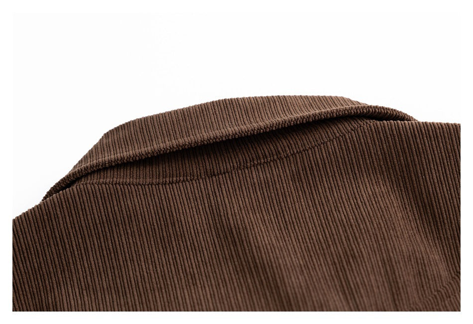 Close-up of the pointed collar and ribbed texture of a brown corduroy garment.