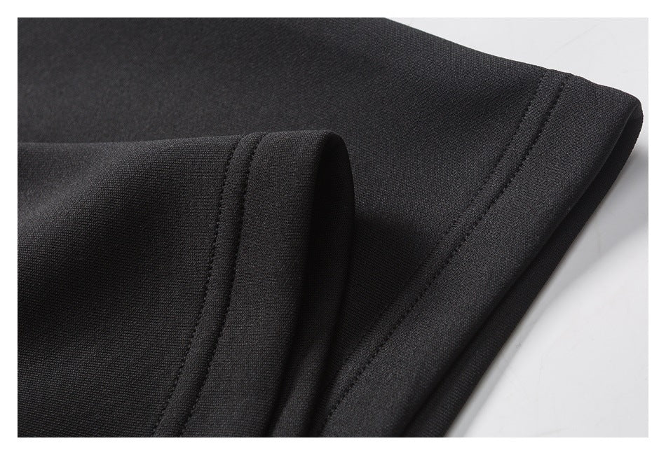 Close-up of black garment fabric and a neatly stitched folded hem.