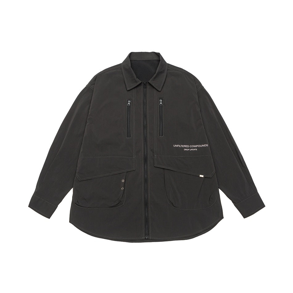 Dark charcoal zip-front shirt-style jacket flat lay with zip chest pockets, flap pockets and small chest text