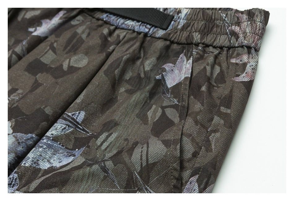 Close-up of the side seam and pocket area on dark camouflage-print pants.