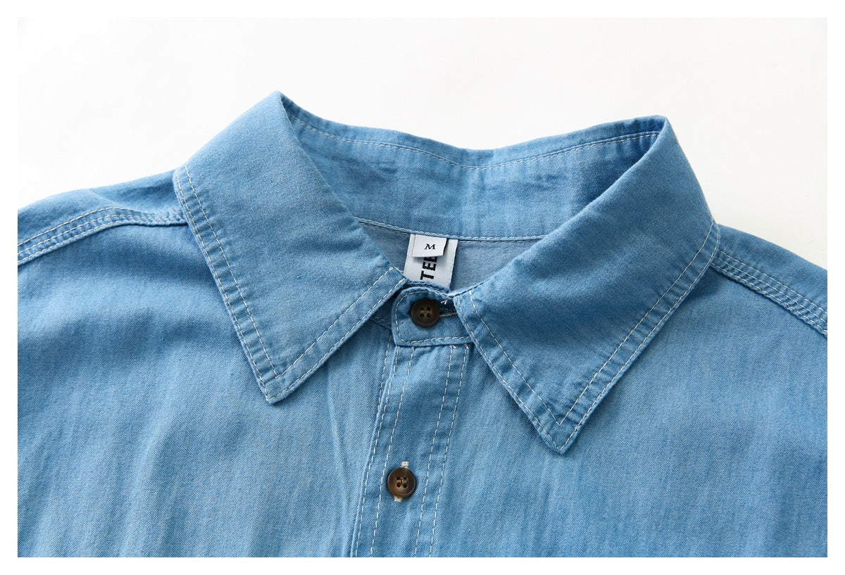 Close-up of a light blue shirt collar, top buttons, and contrast stitching.