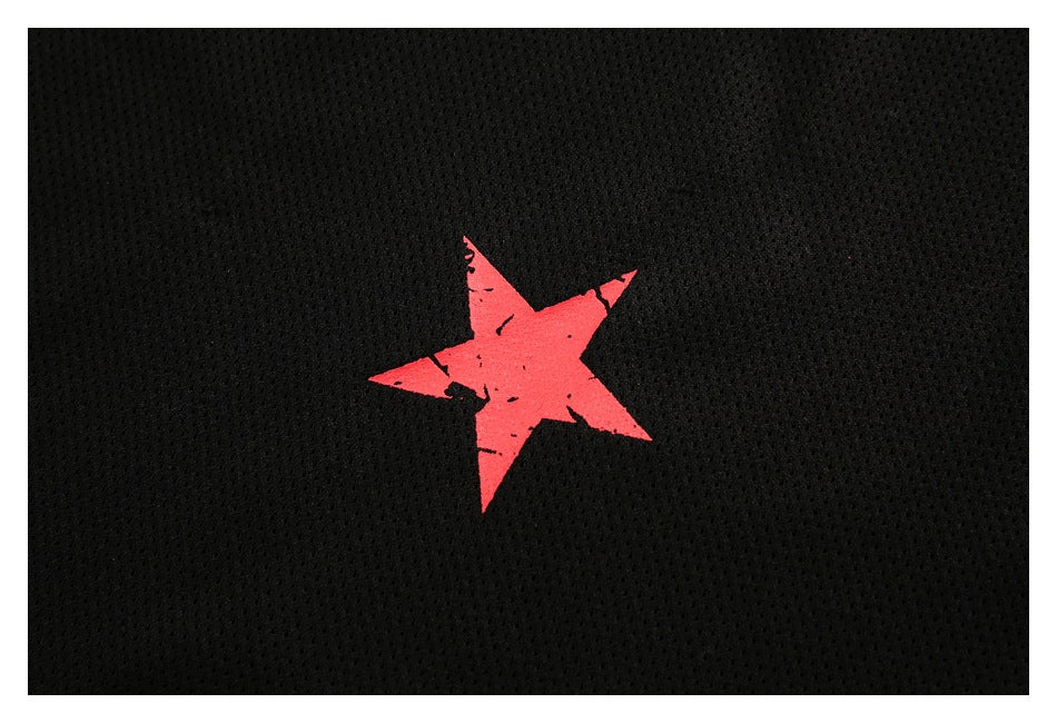 Close-up of a distressed red star graphic on black mesh fabric.