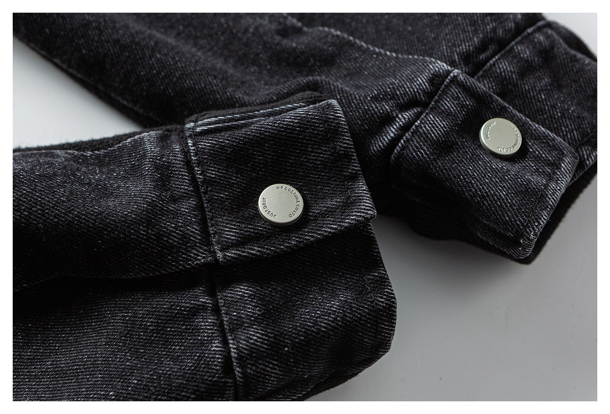 Close-up of black garment cuffs with silver snap buttons and stitched edges.