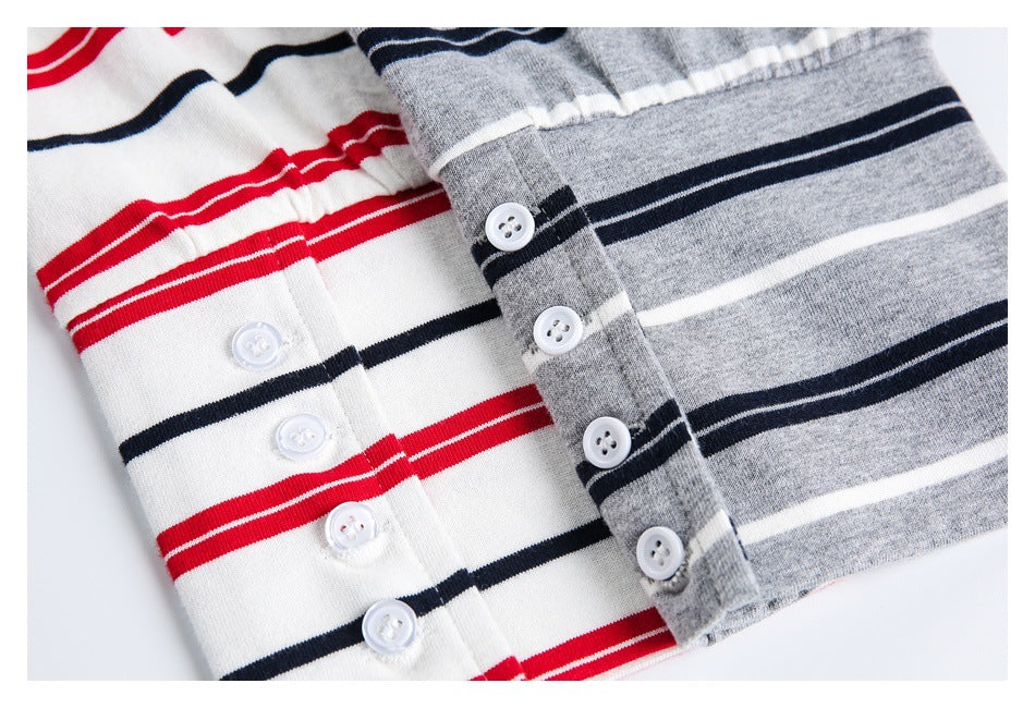Close-up of button plackets on gray and white striped shirts, with white buttons and navy, white, and red stripes.
