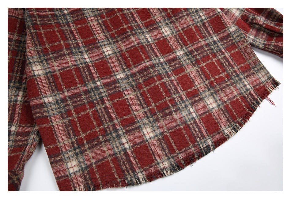 Close view of the shirt's red, cream, and charcoal plaid back with a frayed hem.