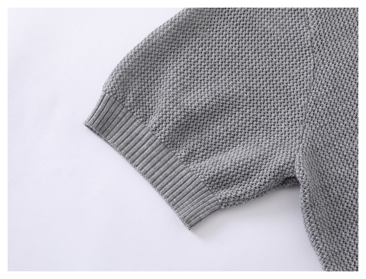 Close-up of the gray sweater's textured sleeve and ribbed cuff.