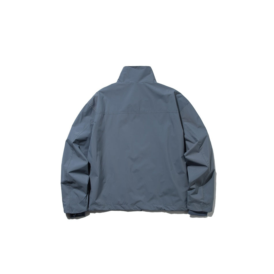 Back view of haze blue stand-collar jacket with horizontal yoke seam across the upper back