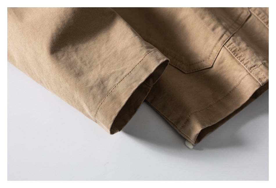 Close-up of the tan jacket sleeve cuff and lower hem with visible stitching.