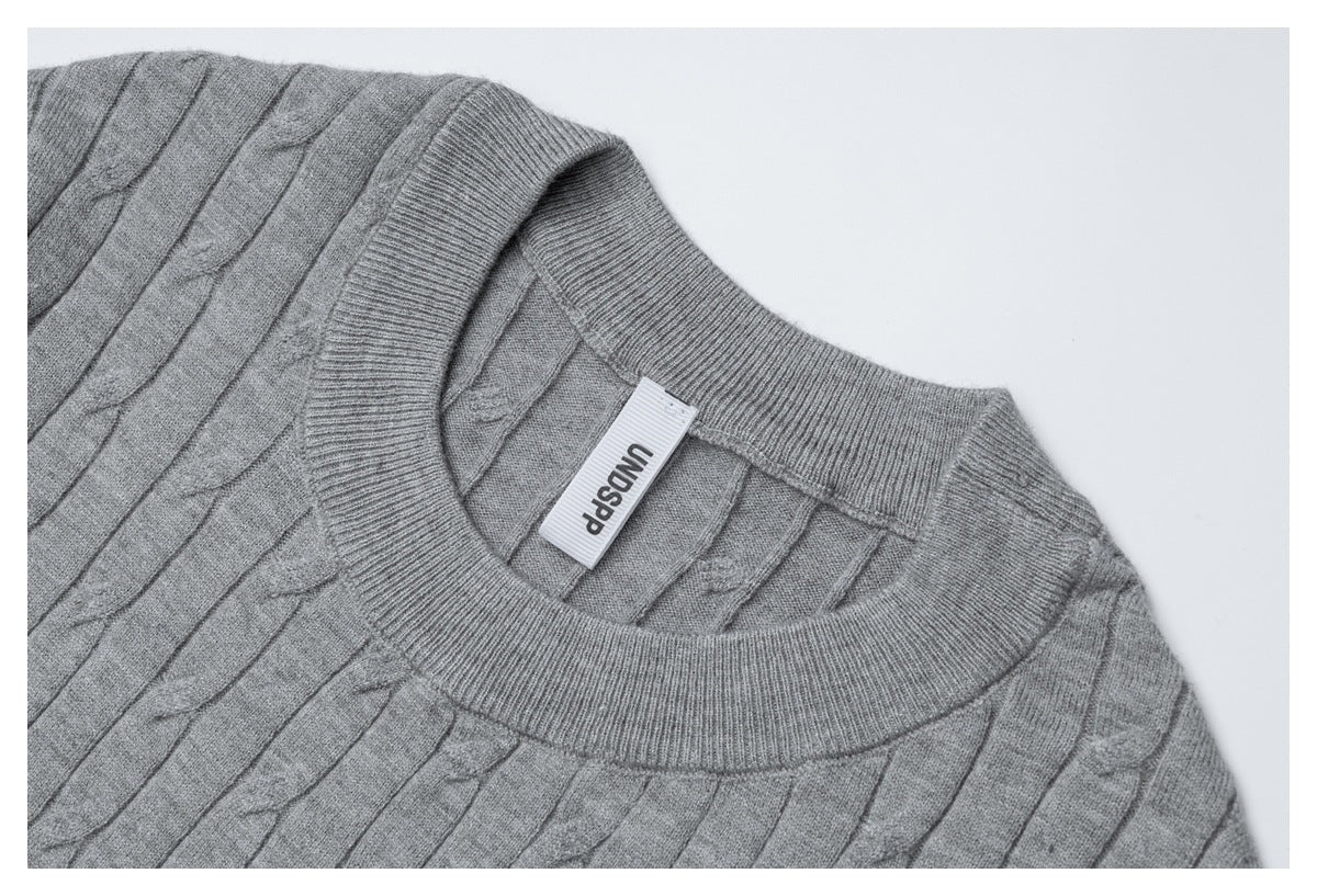 Close-up of the gray knit top's ribbed crew neckline and attached garment label.