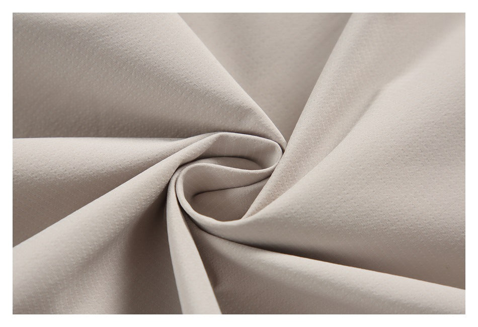 Light beige fabric gathered into a spiral fold, showing its texture and drape.