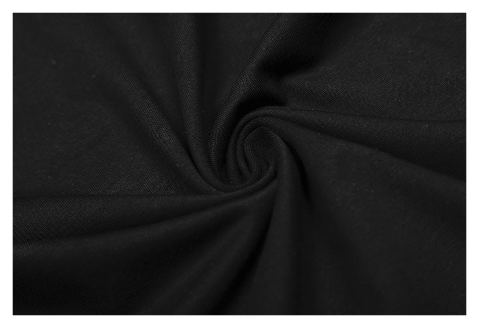 Close-up of black fabric gathered into folds, showing its surface texture.