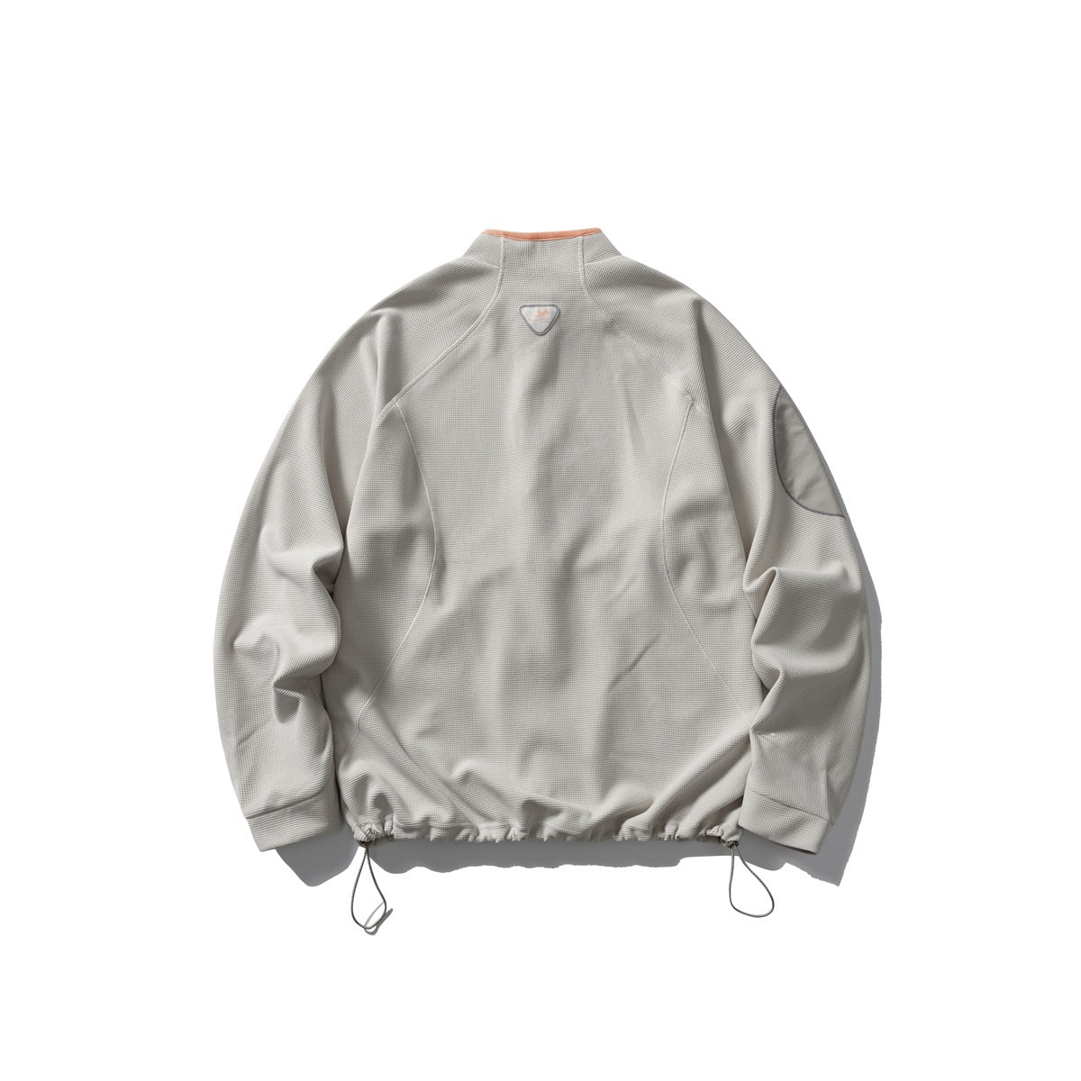 Back view of an off-white jacket with a stand collar, sleeve patch, curved seams and adjustable hem cords.
