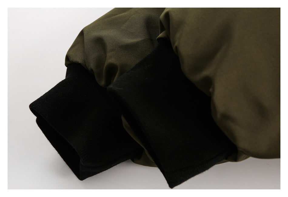 Close-up of olive jacket sleeves with wide black ribbed cuffs.