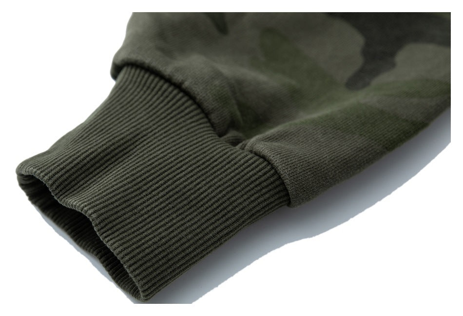 Close-up of a dark olive camouflage sleeve ending in a wide ribbed cuff.