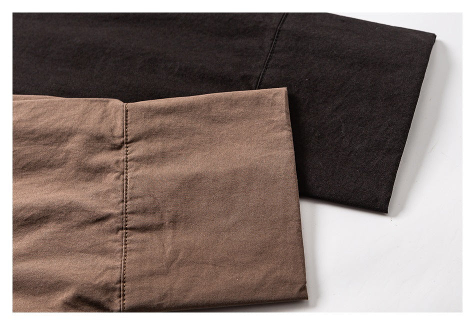 Close-up comparison of brown and dark shirt sleeves, showing the cuffs and stitching.