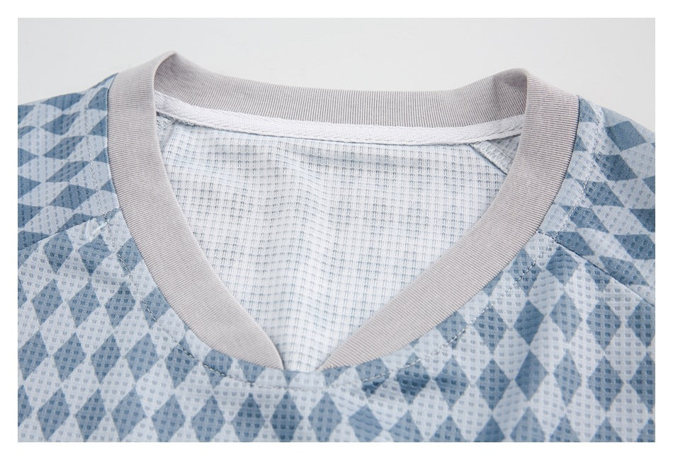 Close-up of a blue diamond-patterned jersey's pale ribbed V-neck and mesh inner panel.