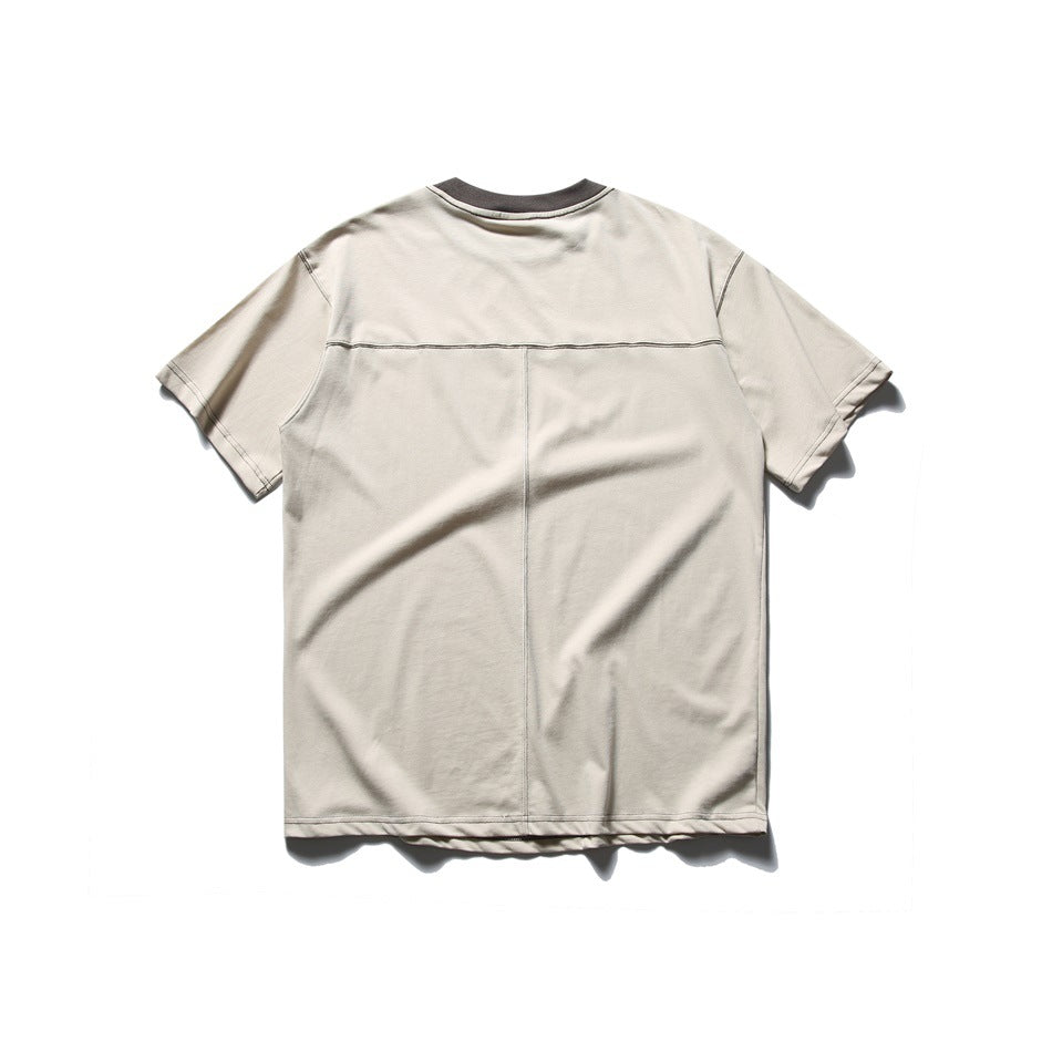 Back of beige short-sleeve T-shirt with dark gray collar, yoke seam and center back seam, flat lay