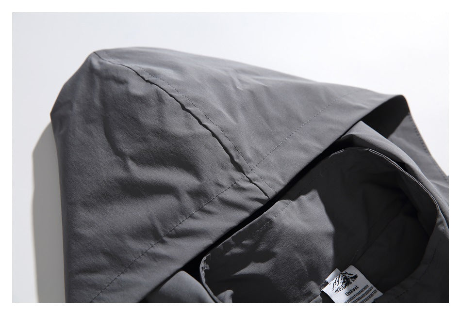Close-up of the charcoal-gray garment's hood and inner neck area, with a small sewn-in label visible.