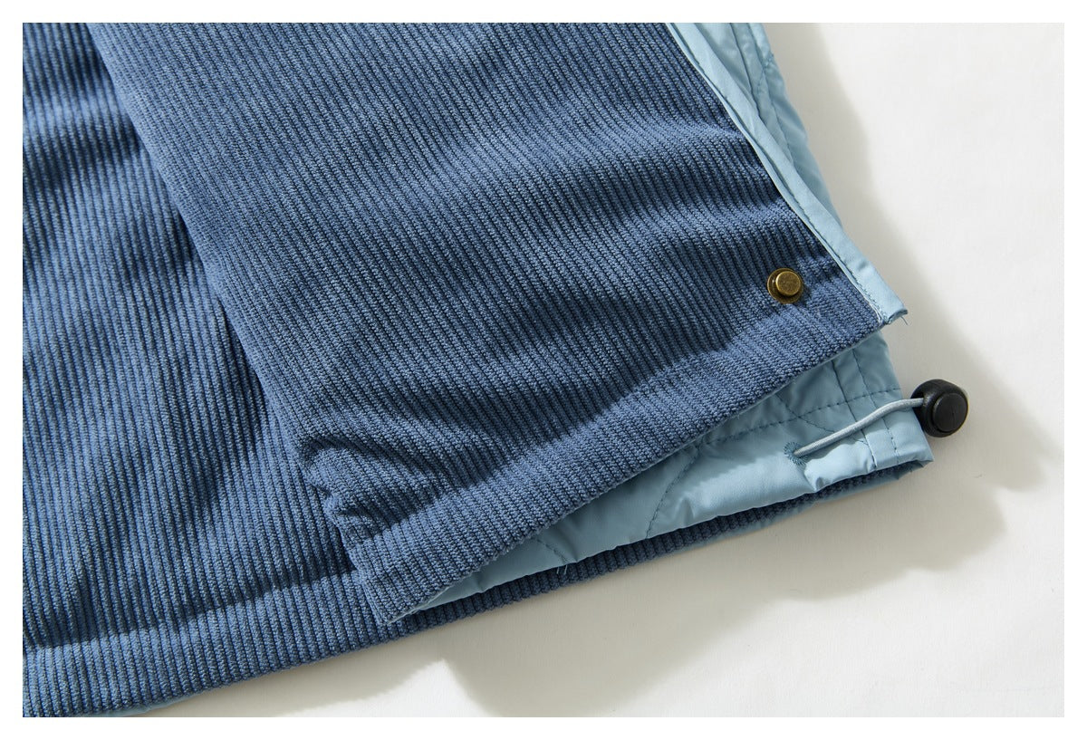 Close-up of a jacket hem showing dark blue ribbed lining, pale blue quilted shell, and an adjustable drawcord.