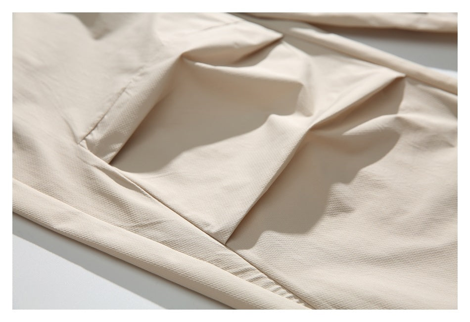 Close-up of cream pants fabric and stitched pocket seams.