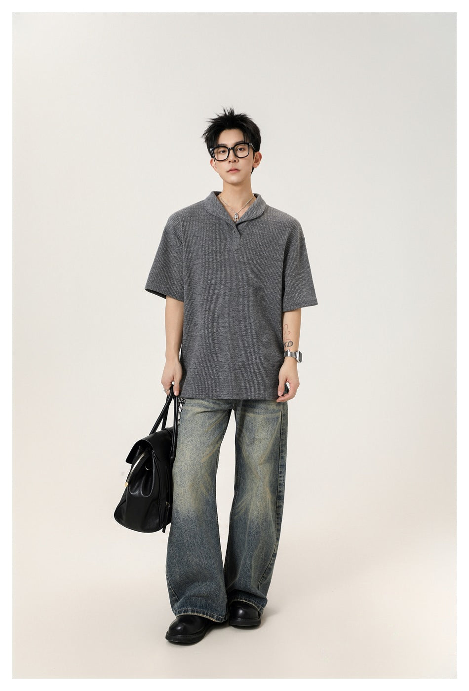 Full-length model wearing a charcoal gray short-sleeve textured polo with a shawl collar and button placket.