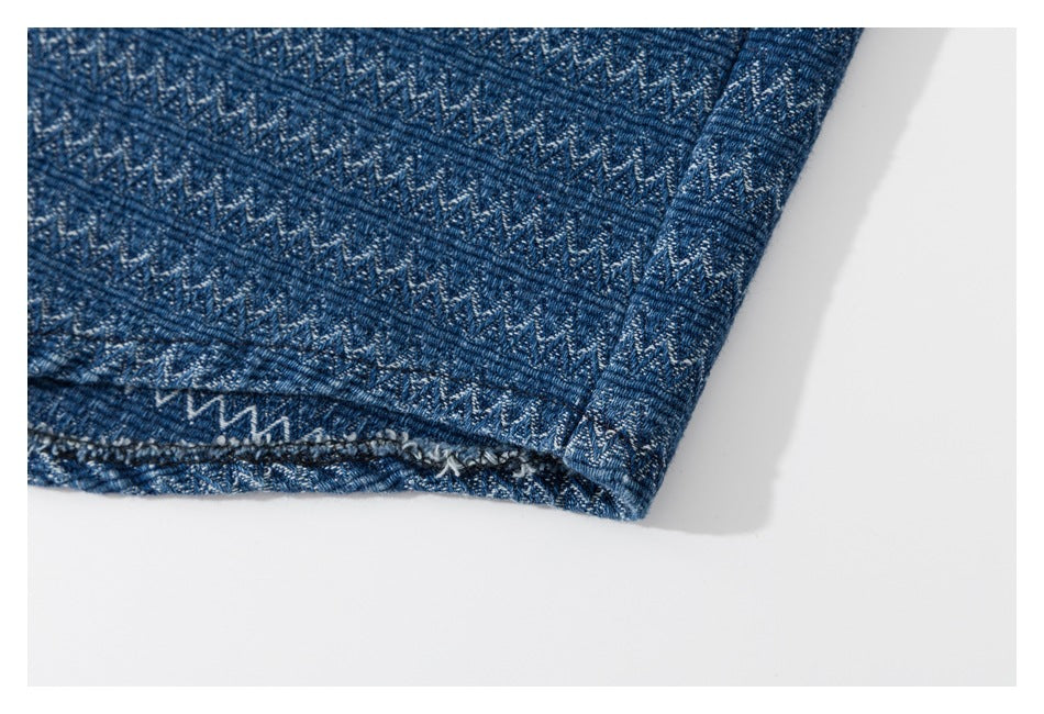 Close-up of a blue patterned garment hem with visible stitching and a folded edge.