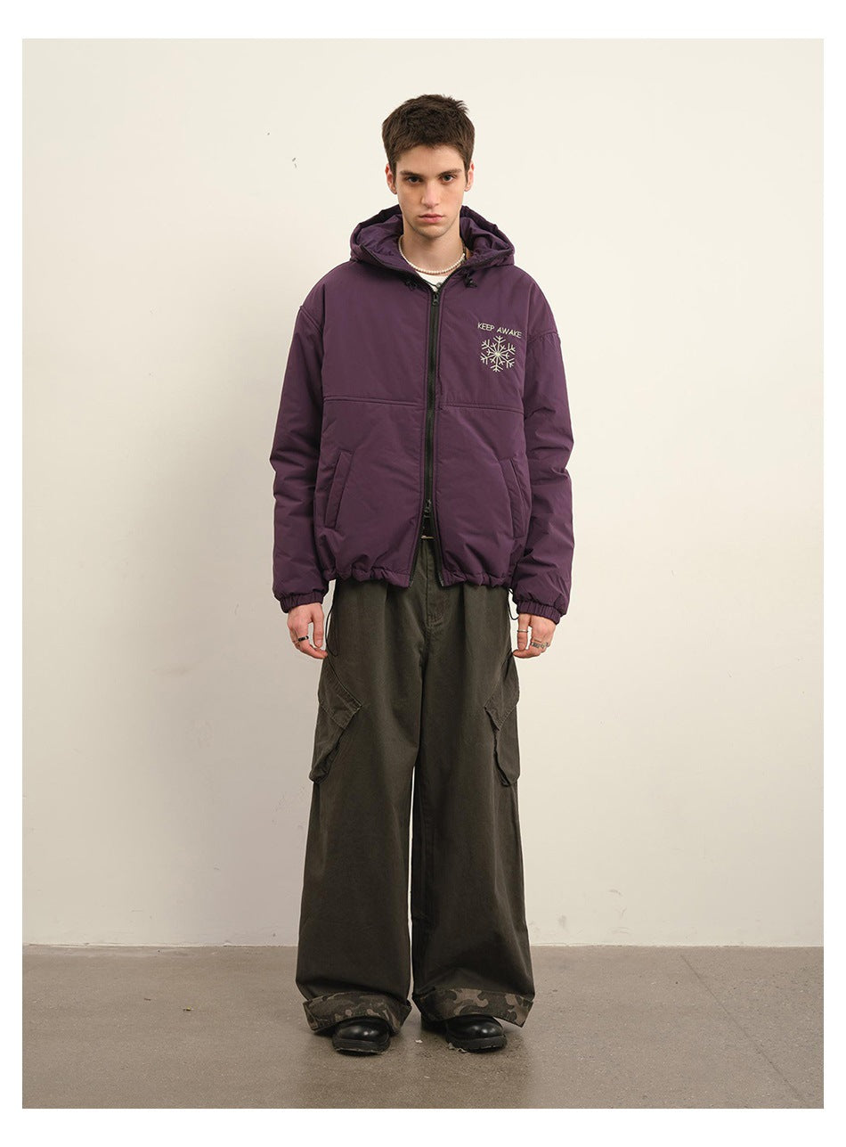 Model wearing a plum hooded zip jacket with chest embroidery and dark cargo pants, shown from the front.