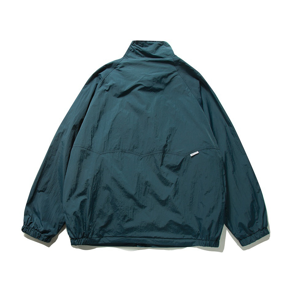 Back view of a dark teal jacket with a tall collar, gathered cuffs, and a horizontal back seam.