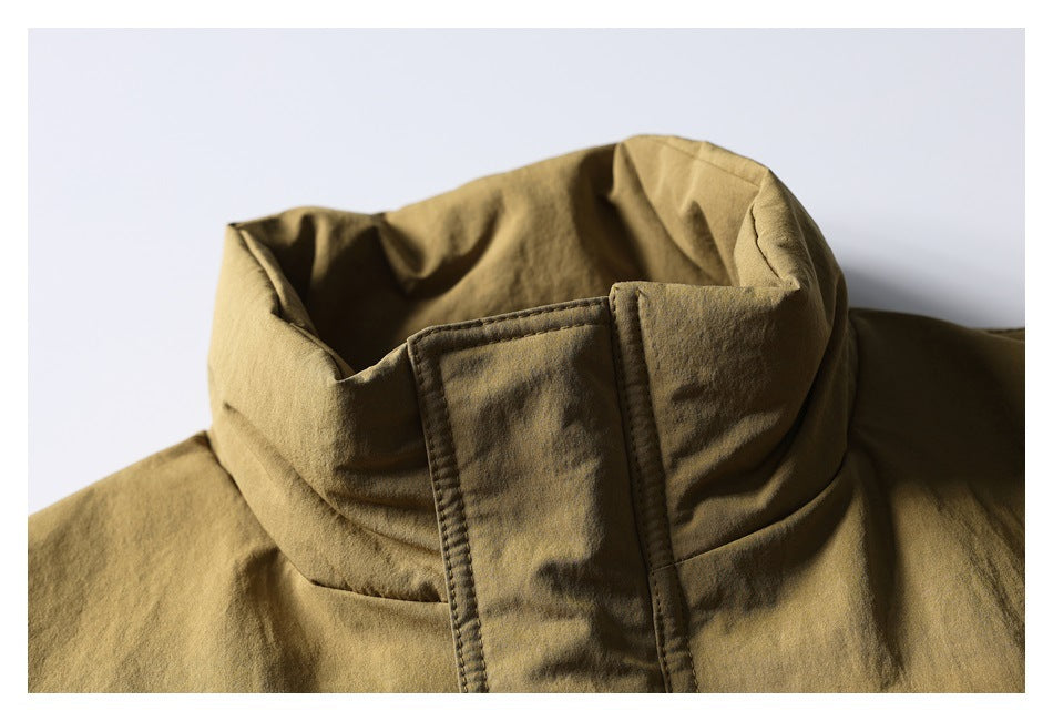 Close-up of a tan jacket's tall stand collar and snap storm flap.