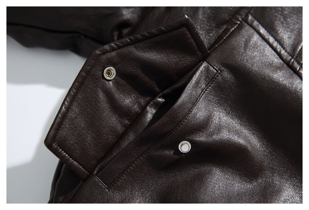 Close-up of a dark brown jacket tab with snap fasteners and stitched seams.