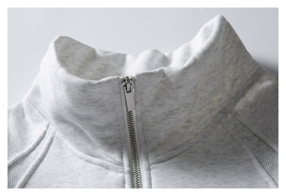 Close-up of a light gray zip-up jacket's tall collar, metal zipper, and seam details.