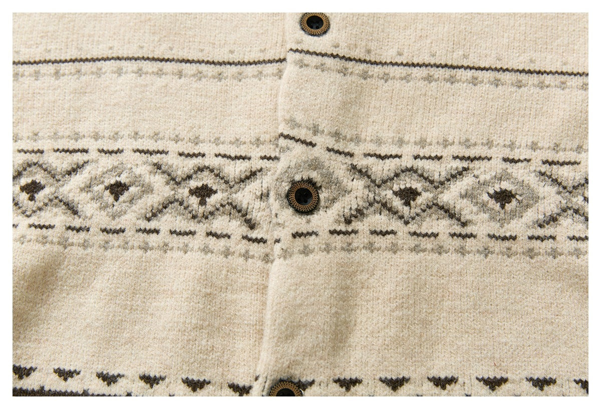 Close-up of a cream cardigan front with dark geometric knit bands, a button placket, and decorative buttons.