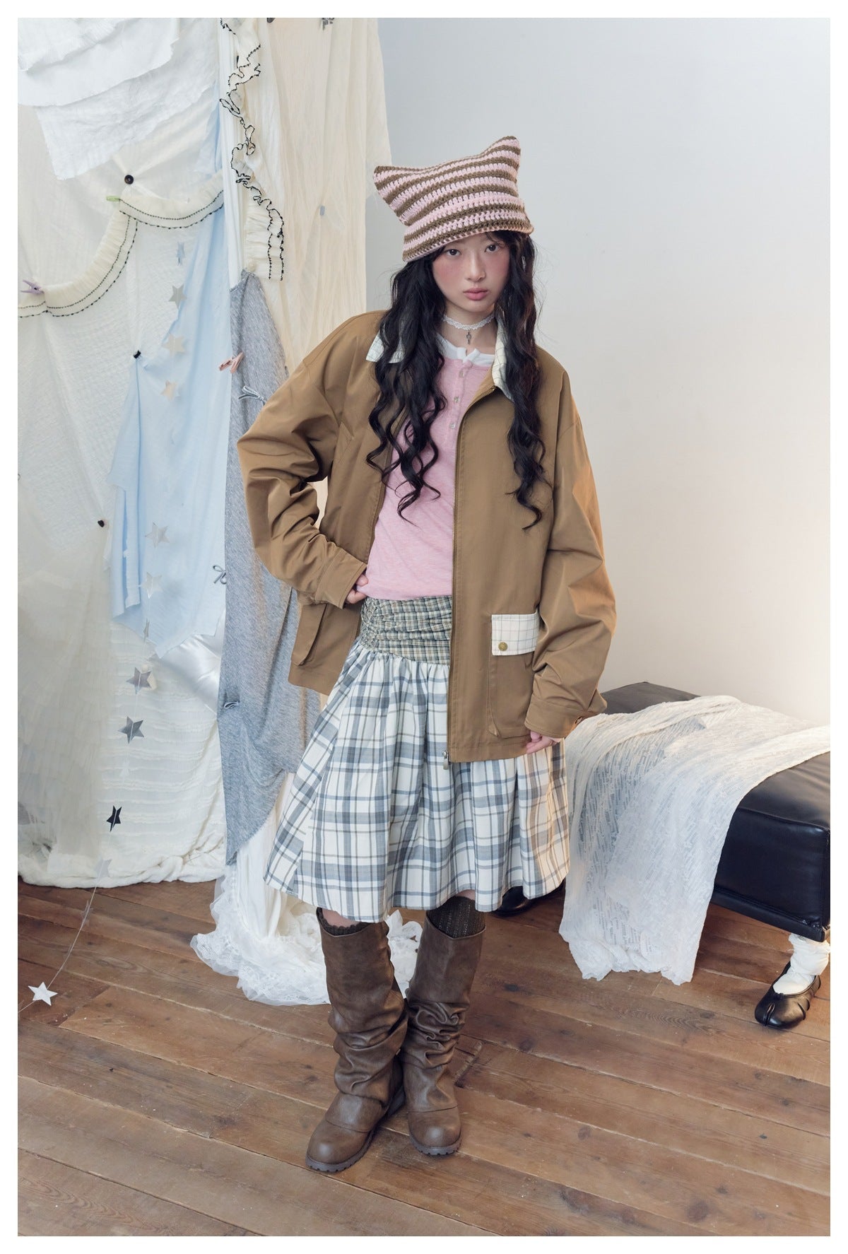 Full-length model wearing a brown jacket with a plaid pocket detail and a blue-gray plaid skirt.