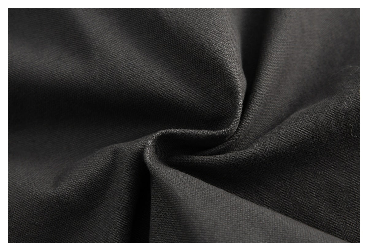 Macro close-up of dark charcoal woven fabric gathered into soft folds.