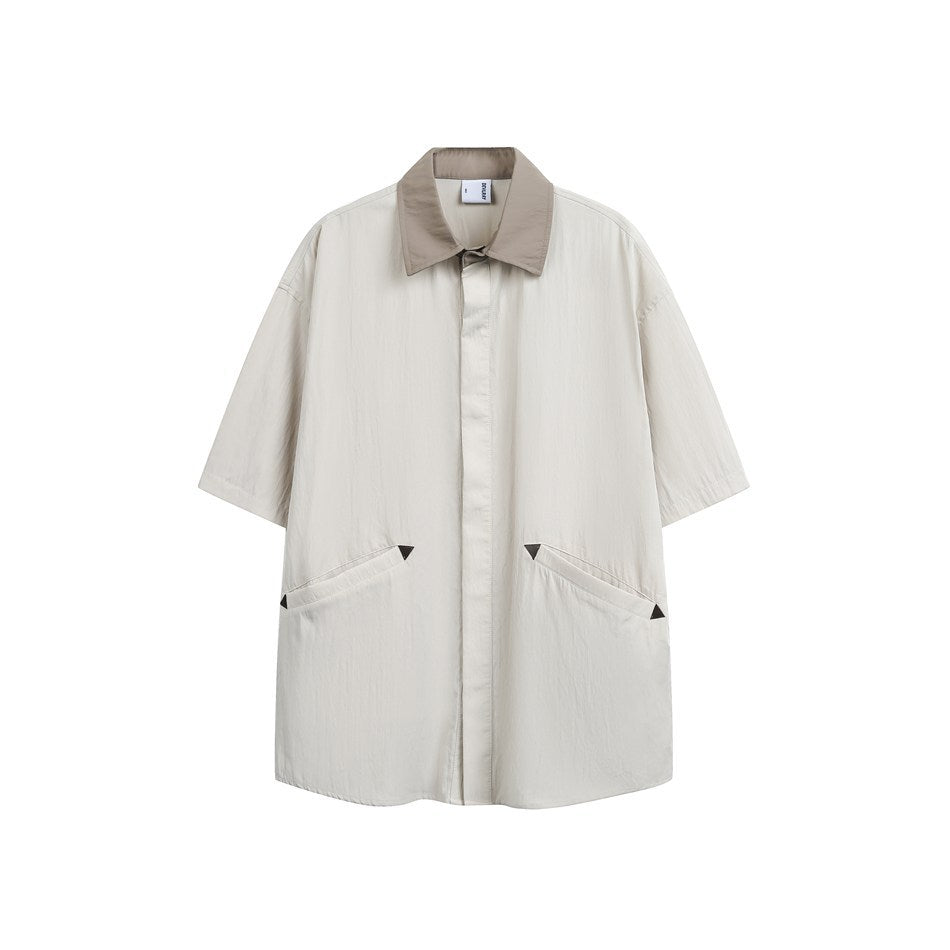 Sand short-sleeve shirt with taupe collar and angled front pockets with black triangle accents, flat front view
