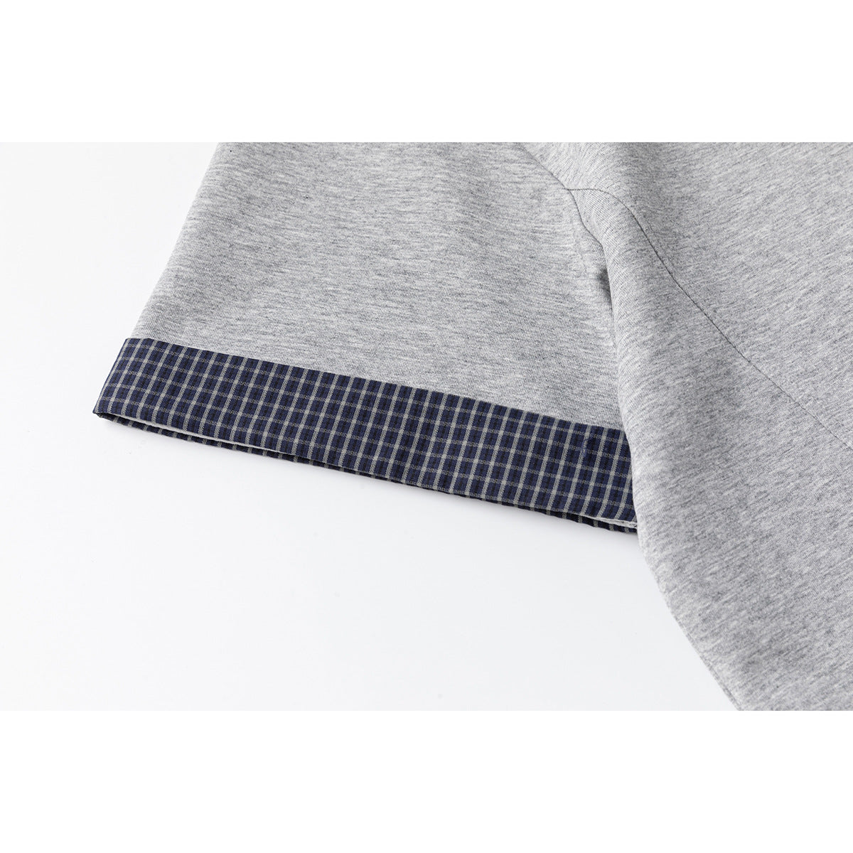 Close-up of a gray T-shirt sleeve with a dark plaid cuff trim.