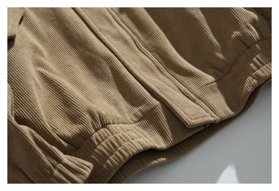 Close-up of tan corduroy garment details, including a front fastening and gathered elastic edge.