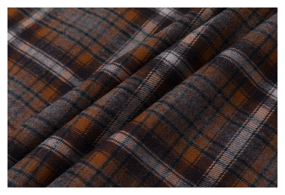Close-up of brown, charcoal, and cream plaid fabric arranged in soft folds.