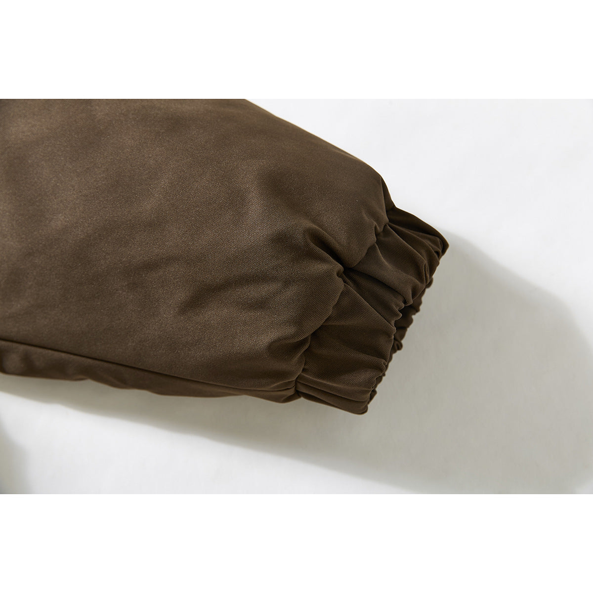 Close-up of the dark brown jacket's gathered sleeve cuff.