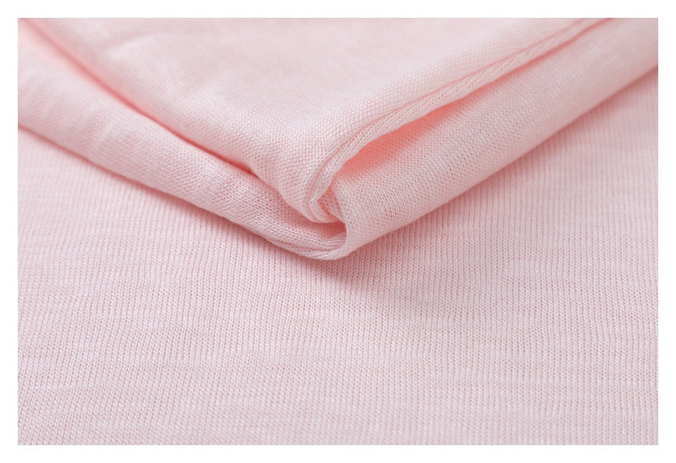 Close-up of pale pink knit fabric folded to show its texture and edge.